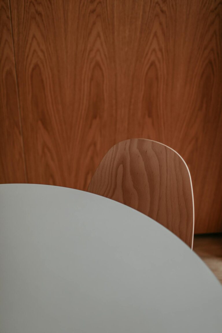 Stylish minimalist design featuring a wood grain chair and sleek white table.
